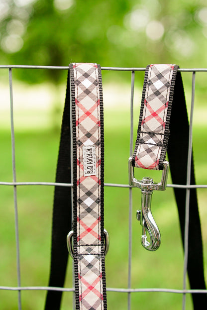 Beige plaid leash and matching collar hanging on a fence; collar not included
