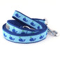 Dark blue whales with water spouts on light blue ribbon nylon dog leash, coiled