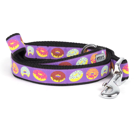 Colorful donut illustrations on purple ribbon nylon dog leash, coiled