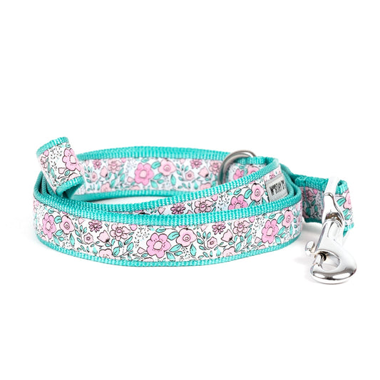 Pink flowers with green foliage on pale ribbon nylon dog leash, coiled