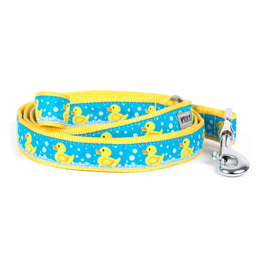 Yellow rubber-duck illustrations on blue ribbon nylon dog leash, coiled