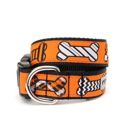 Black and white patterned bones on orange ribbon Halloween dog collar, front view
