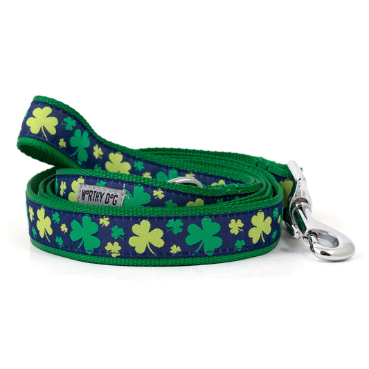Green clover shapes on navy ribbon nylon dog leash, coiled