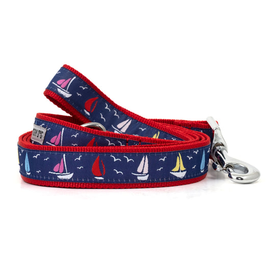 Repeating sailboat illustrations on navy ribbon nylon dog leash, coiled
