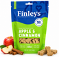 Finley's Apple & Cinnamon baked dog treats in a blue and green stand-up pouch, shown with whole and sliced red apples and cinnamon sticks on a white background.
