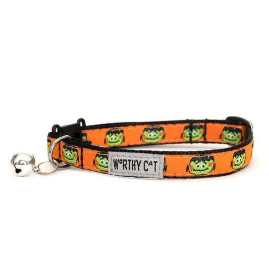 Frankenstein faces on orange ribbon Halloween cat collar, front view with bell