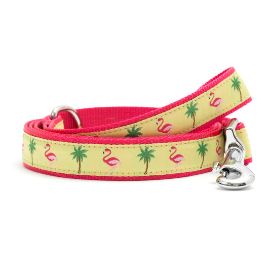 Pink flamingos and green palm trees on yellow ribbon nylon dog leash, coiled